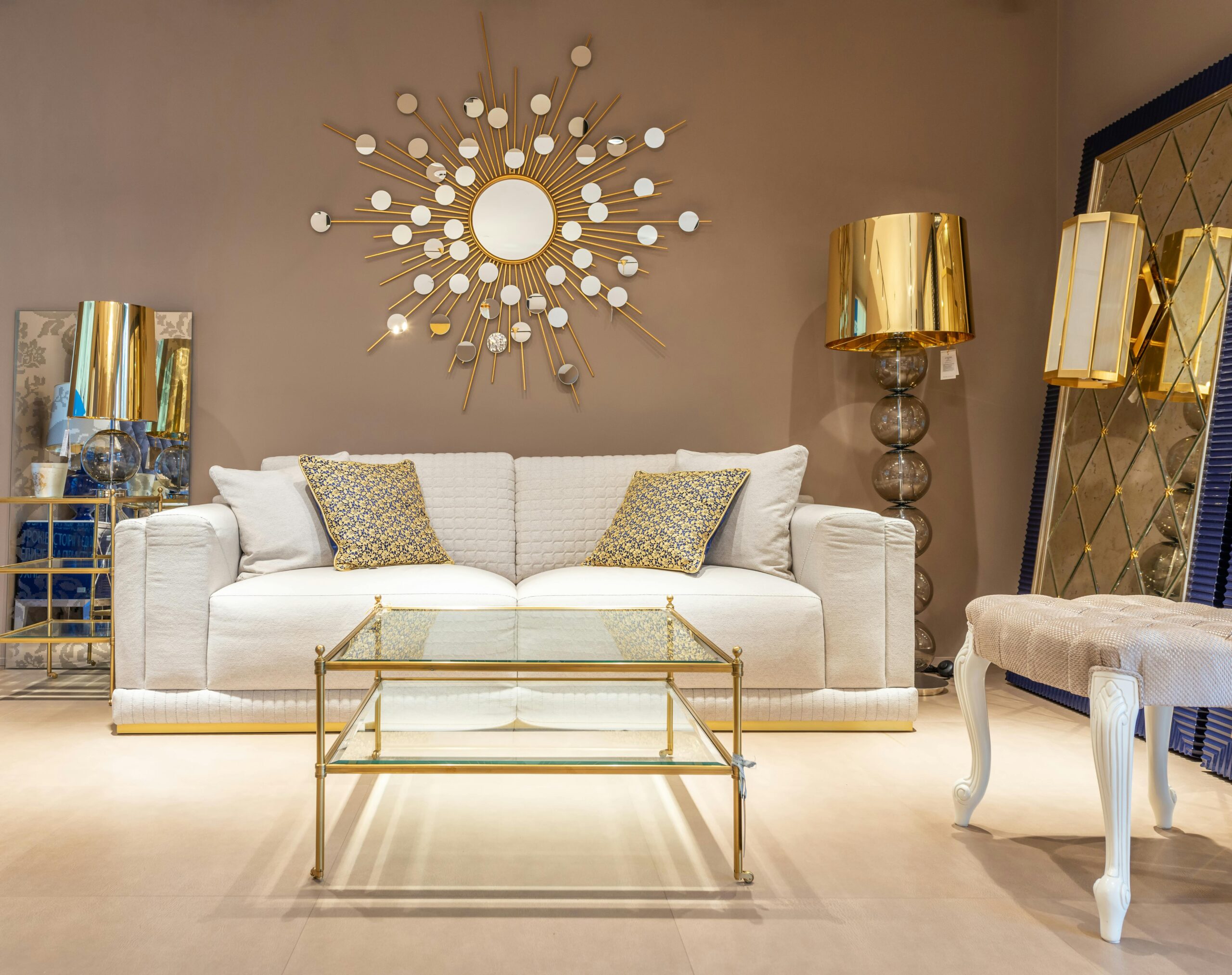 Stylish living room with white sofa, gold decor, and glass table for modern homes.